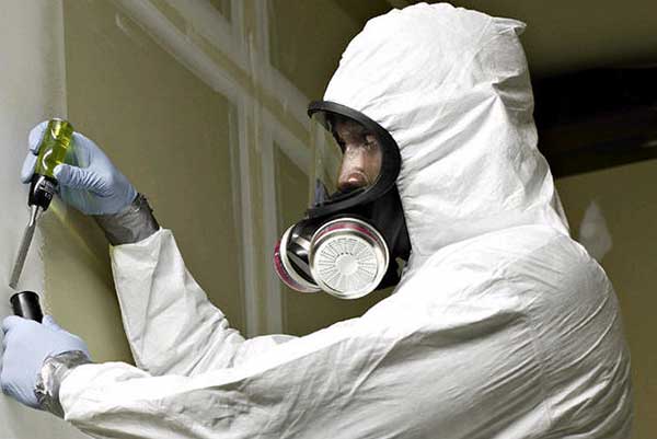 inspector in protective suit checking for asbestos
